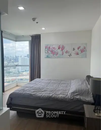 Modern bedroom with city view and stylish decor in high-rise apartment.