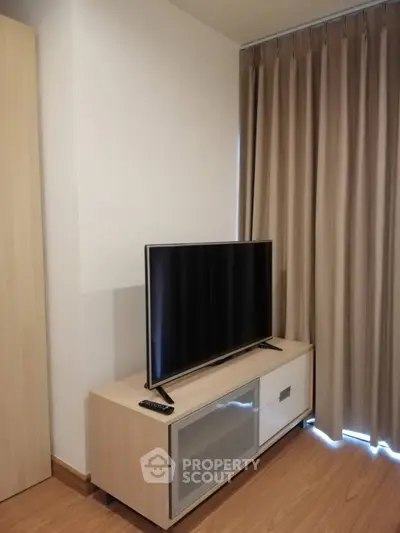 Modern living room with sleek TV stand and floor-to-ceiling curtains