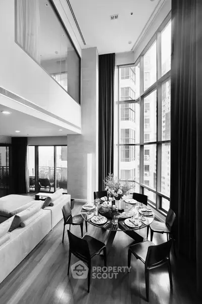 Luxurious modern living room with high ceilings and large windows offering stunning city views.