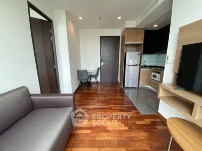 Modern apartment living room with sleek kitchen and wooden flooring