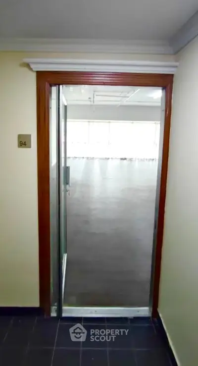 Spacious office entrance with glass door and modern flooring