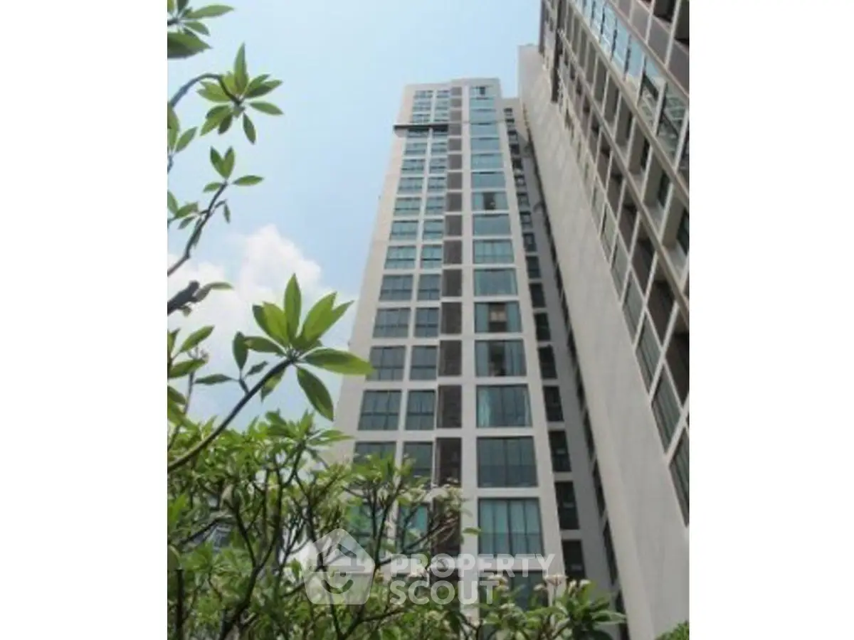Stunning high-rise building with modern architecture and lush greenery, perfect for urban living.