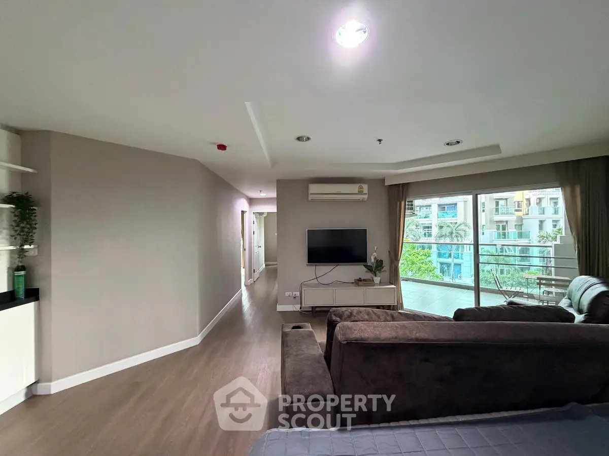 Spacious living room with modern decor and large balcony view.