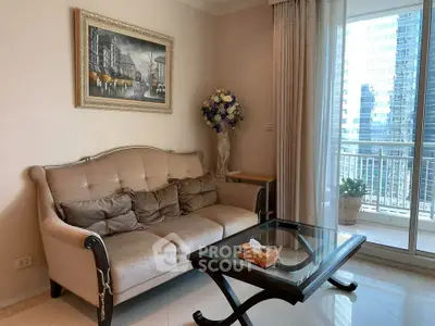 Elegant living room with plush sofa, glass coffee table, and balcony view in modern apartment.