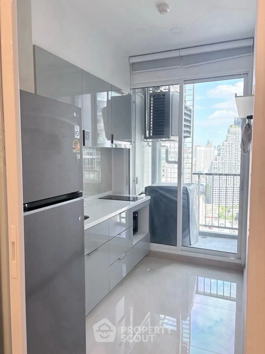 Modern kitchen with sleek cabinets and city view from balcony
