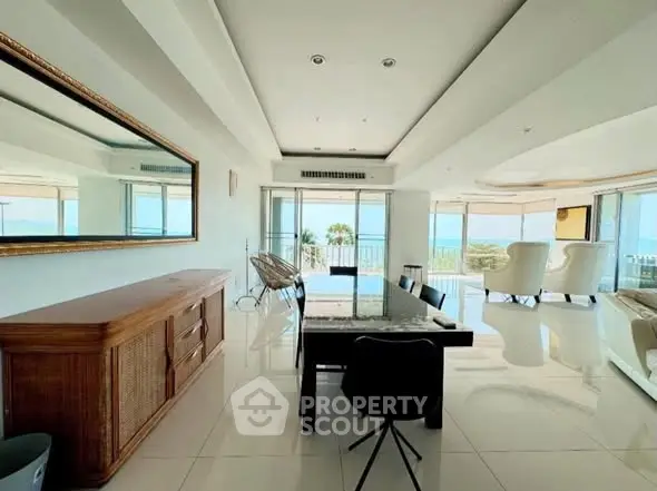 Spacious living room with ocean view, elegant decor, and abundant natural light.