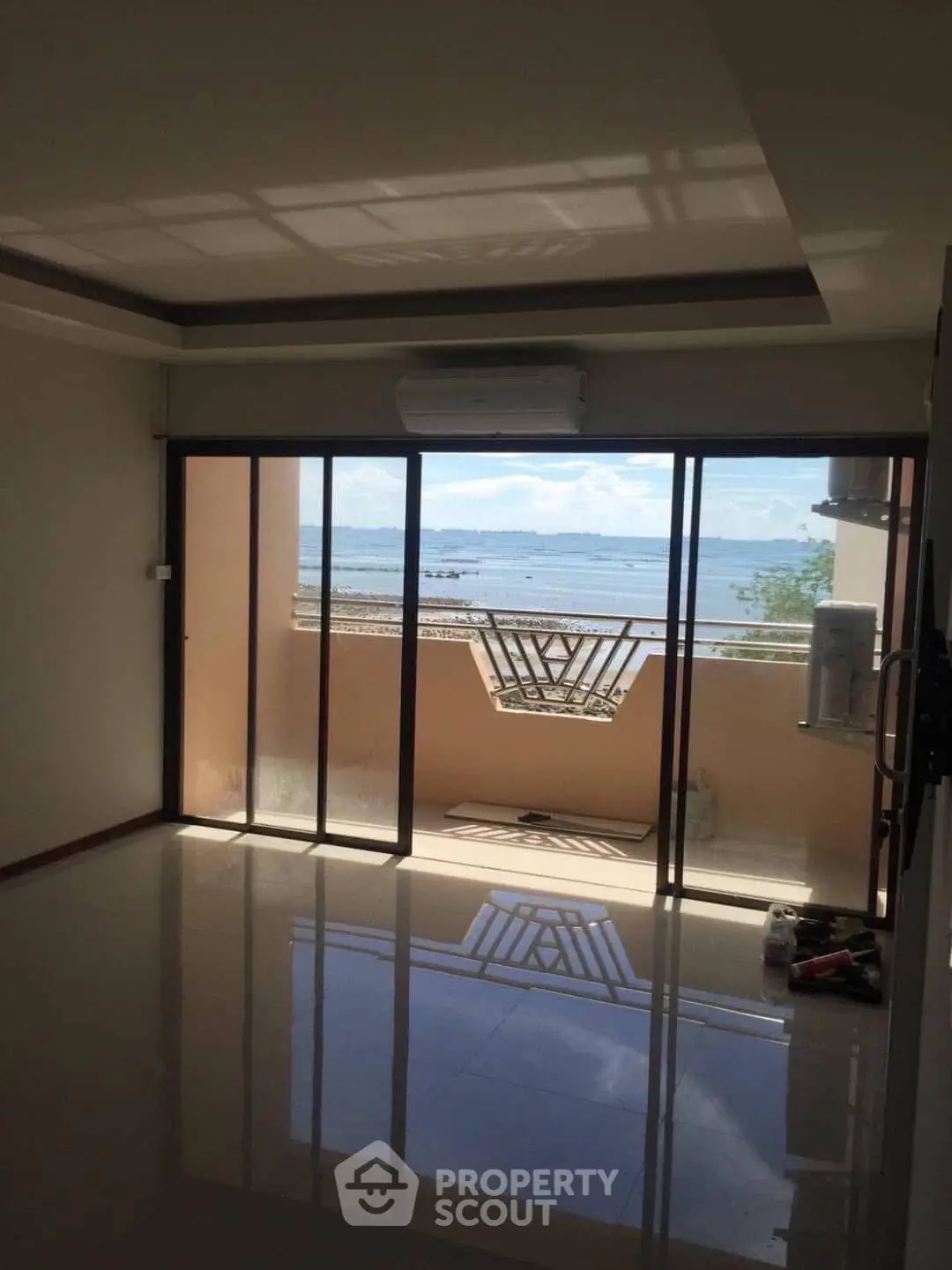 Spacious living room with stunning ocean view through large glass doors.