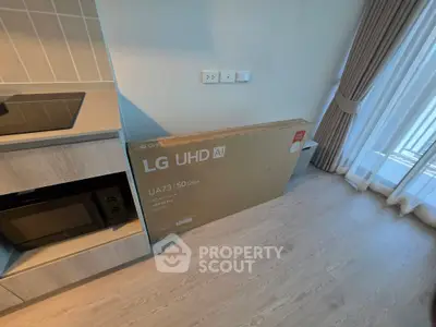 Modern kitchen with sleek cabinetry and large window, featuring a new LG UHD AI TV box on the floor.