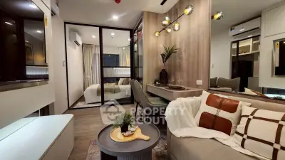 Modern living room with stylish decor and open layout leading to a cozy bedroom.