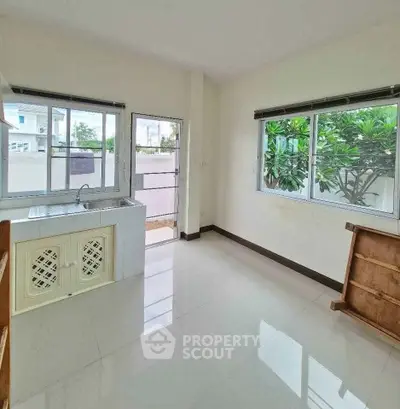 Bright kitchen with large windows and garden view, perfect for culinary enthusiasts.