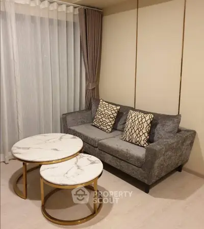 Elegant living room with plush gray sofa and marble coffee tables