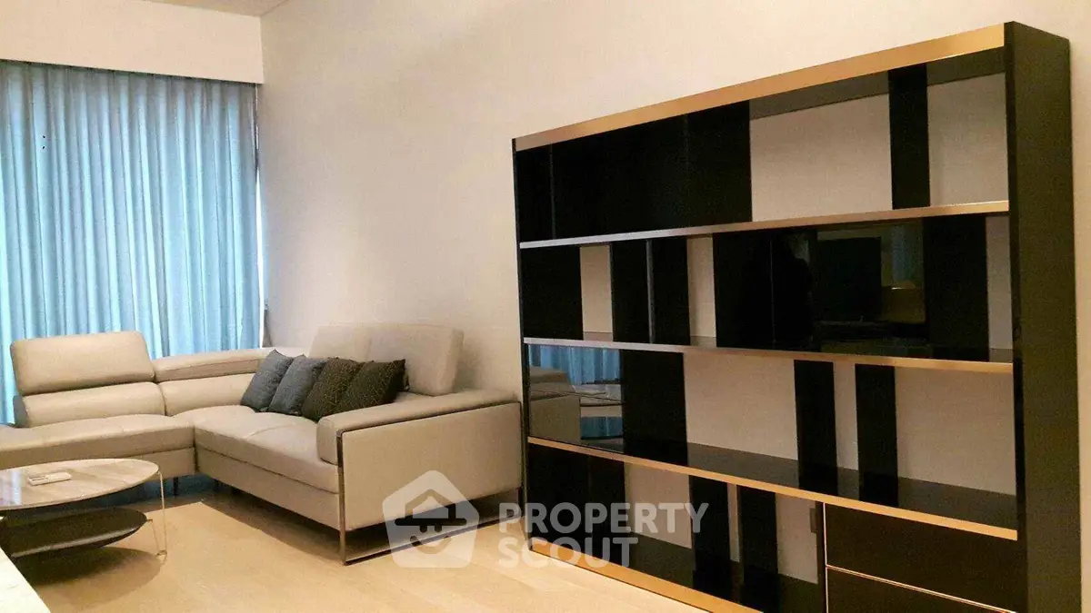 Modern living room with sleek black bookshelf and cozy sectional sofa