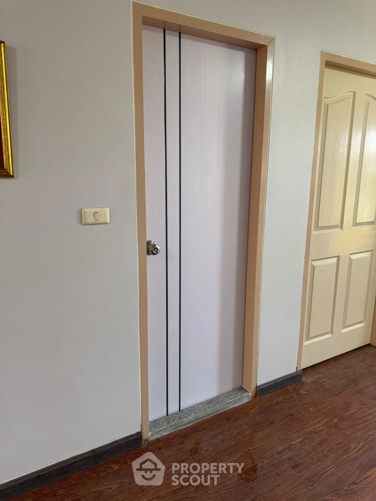 Minimalist interior hallway with wooden flooring and closed doors