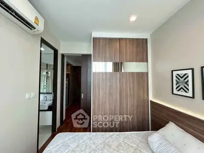 Modern bedroom with stylish wooden wardrobe and cozy bed in a contemporary apartment.