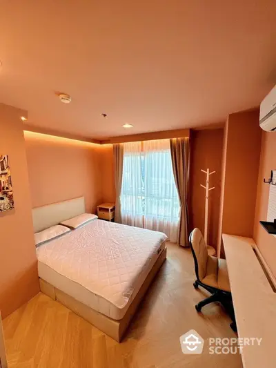 Cozy bedroom with modern furnishings and natural light, featuring a comfortable bed and workspace.