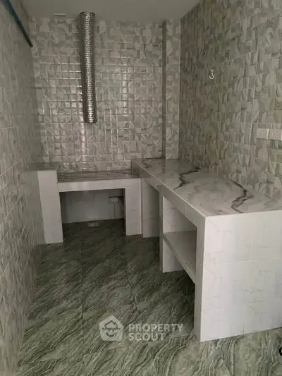 Spacious kitchen with marble countertops and tiled walls, perfect for culinary enthusiasts.