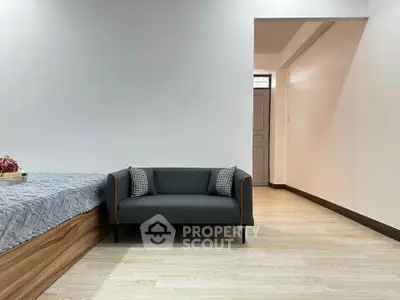 Modern minimalist living space with sleek sofa and wooden flooring