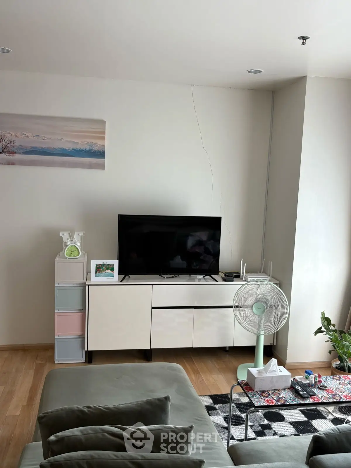 Modern living room with sleek TV stand and cozy seating area, perfect for relaxation.