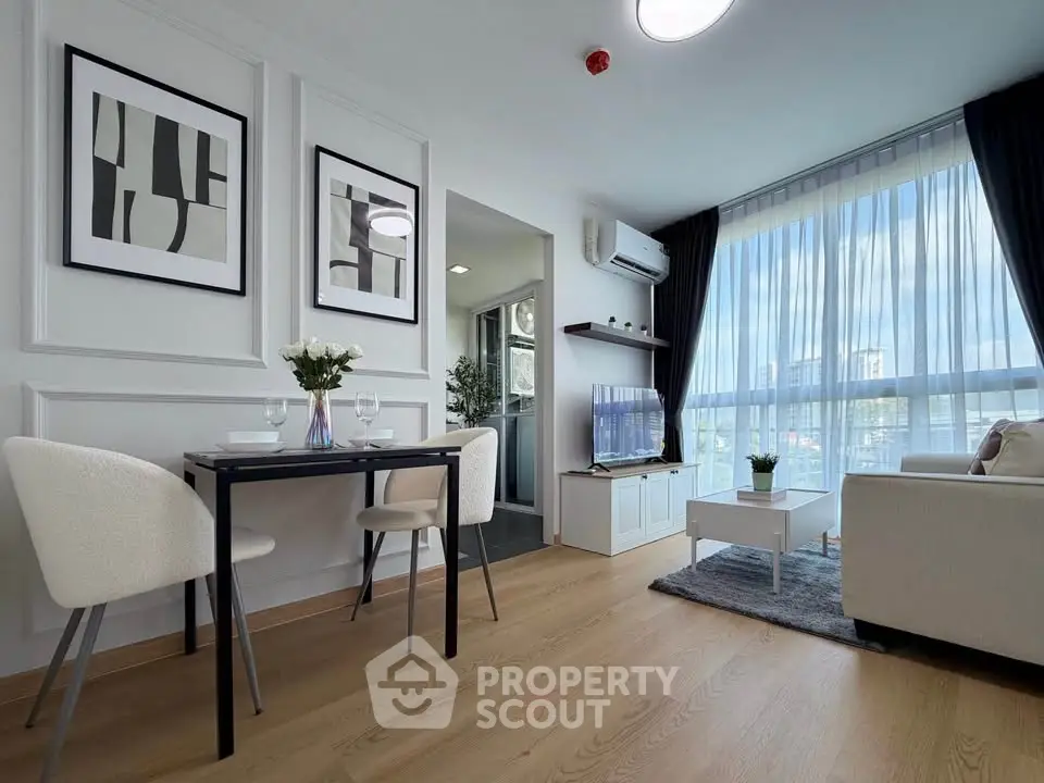 Modern living room with elegant decor and large windows offering natural light.