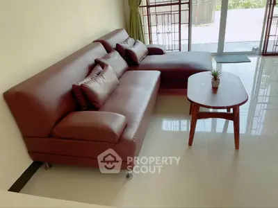 Modern living room with sleek brown leather sofa and stylish wooden coffee table.