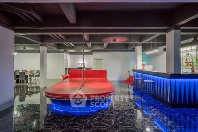Luxurious modern living room with unique red seating and stylish bar area, perfect for entertaining.