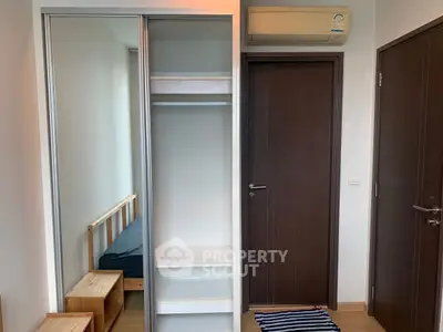 Modern bedroom with built-in wardrobe and air conditioning unit
