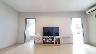 Spacious living room with modern TV setup and minimalist design