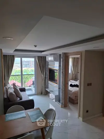 Modern apartment with open living room and bedroom, featuring a scenic view from the balcony.