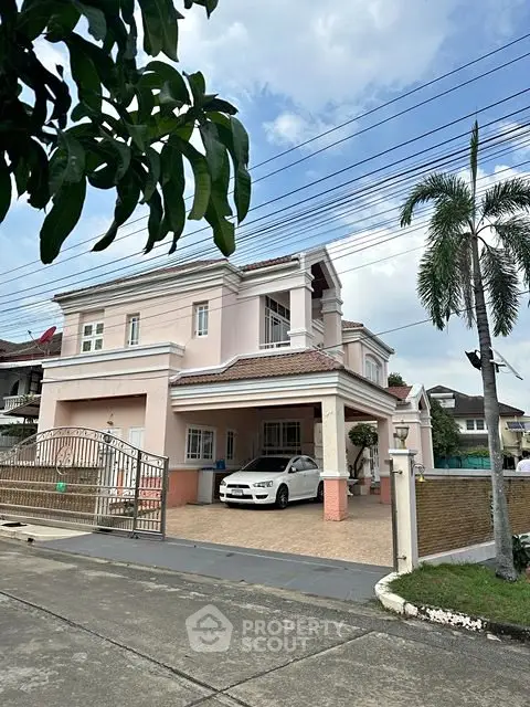 Elegant two-story house with spacious driveway and tropical landscaping
