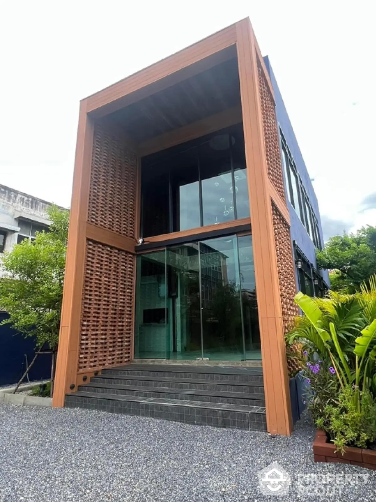 Modern architectural two-story building with glass facade and wooden accents