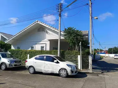 Charming suburban house with white exterior and lush greenery, perfect for family living.