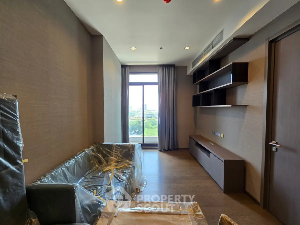 Modern living room with large window and built-in shelves, offering a bright and inviting space.