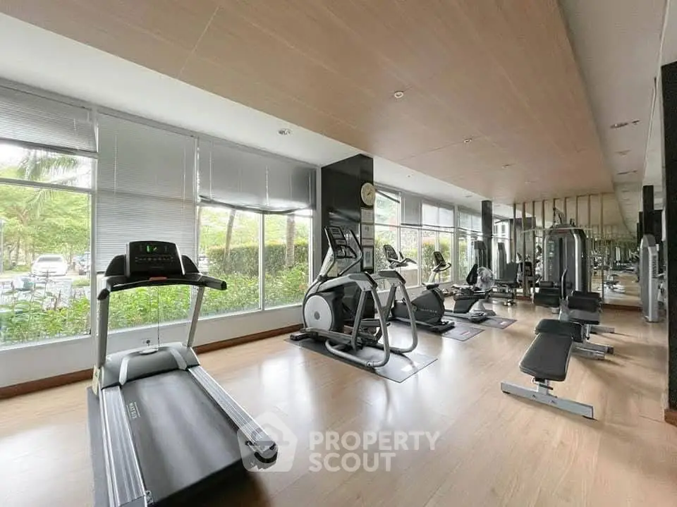 Modern gym with large windows and exercise equipment in a residential building.