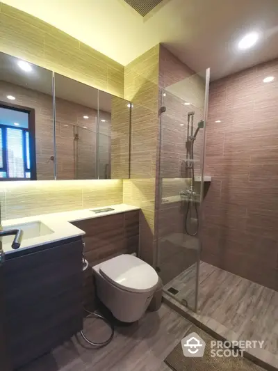 Modern bathroom with glass shower, sleek vanity, and ambient lighting.