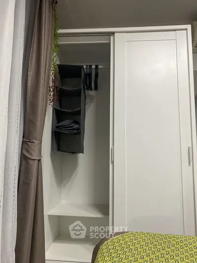 Spacious bedroom with modern wardrobe and stylish curtains, perfect for organized living.