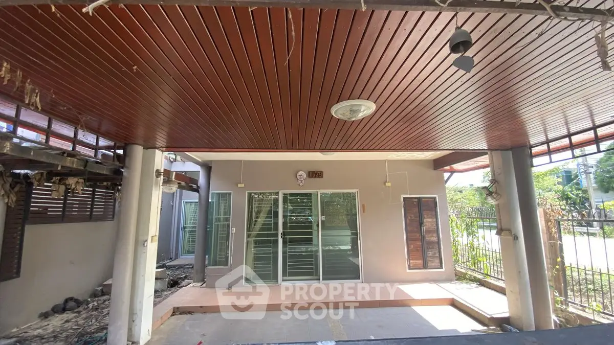 Spacious covered patio area with modern ceiling design and glass doors leading to the interior.