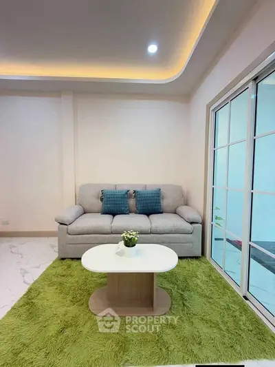 Modern living room with cozy sofa and stylish coffee table on green rug