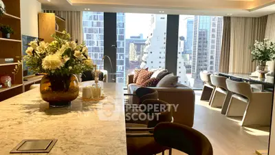 Luxurious modern living room with city view, elegant decor, and spacious seating area.