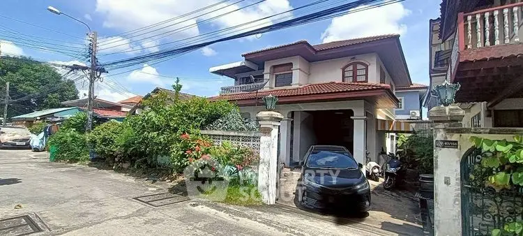 Charming suburban house with driveway and lush garden in a peaceful neighborhood.