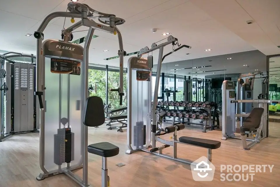 Modern gym with state-of-the-art fitness equipment and mirrored walls in luxury apartment complex.