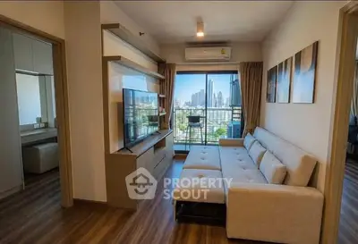Modern living room with city view, featuring sleek furniture and large windows for natural light.