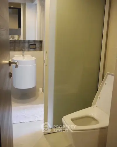 Modern bathroom with sleek fixtures and frosted glass shower door