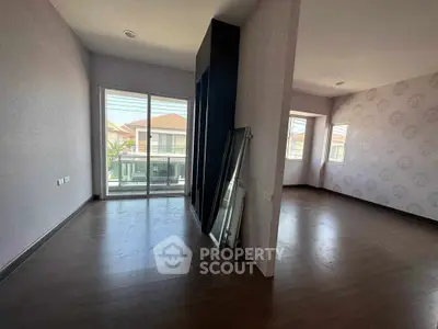 Spacious empty room with large windows and wooden flooring, perfect for customization.