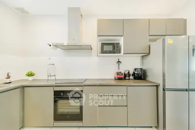 Modern kitchen with sleek cabinetry, built-in oven, and stainless steel appliances.