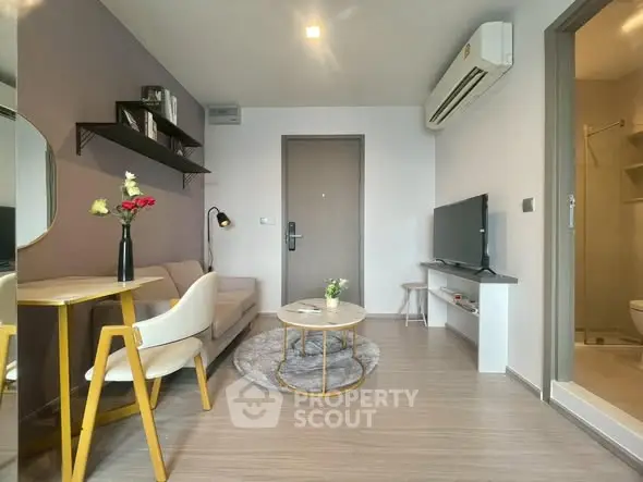 Modern living room with stylish decor and compact design, featuring a cozy sofa and wall-mounted TV.