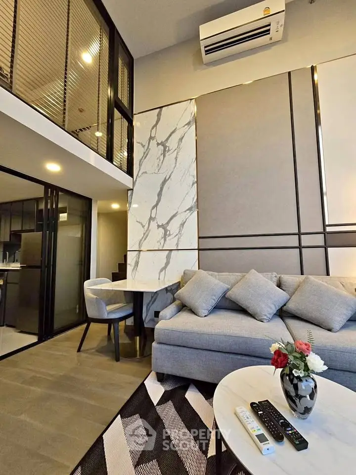 Modern living room with loft design, stylish decor, and open kitchen layout in a contemporary apartment.