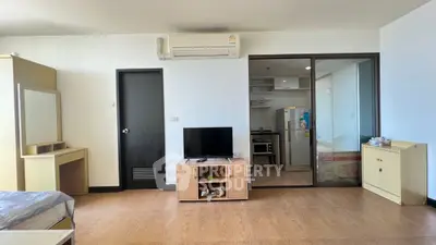 Modern studio apartment with open layout, featuring a compact kitchen and cozy living area.