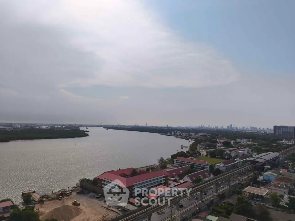 Stunning river view from high-rise building with city skyline in the distance, perfect for urban living.