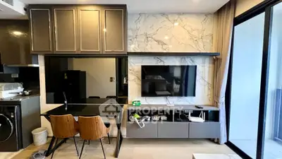Modern living room with sleek furniture and marble accent wall, featuring a wall-mounted TV and large glass doors.