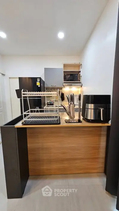 Modern kitchen with sleek appliances and stylish wooden accents